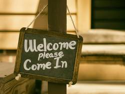 Kreidetafel mit der Aufschrift: Welcome please come in